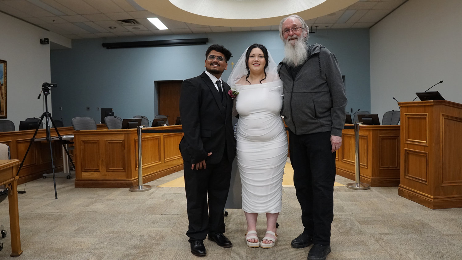 Wedding couple posing with family members in a ceremony room