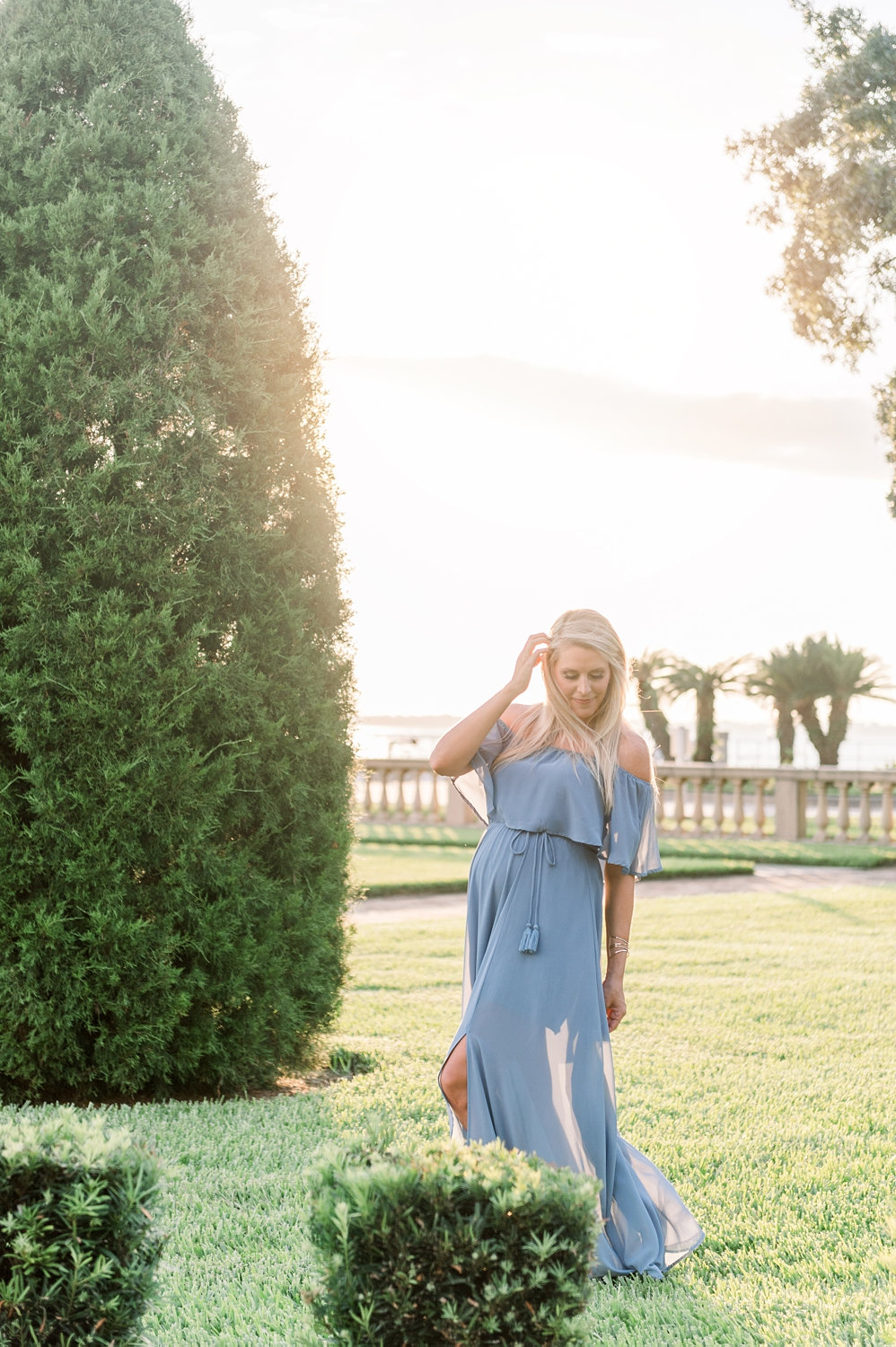 pretty pregnant woman standing in a manicured garden in Jacksonville, Florida